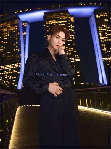 Cover of the photo book showing a man standing on a lit walkway at night with illuminated skyscrapers behind him.
