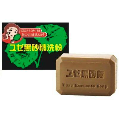 Brown rectangular face soap bar embossed with Japanese and English branding beside a green promotional graphic.