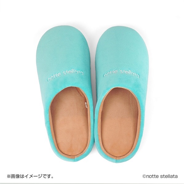Top-down photo of a pair of turquoise room slippers with "notte stellata" embroidered on the uppers.