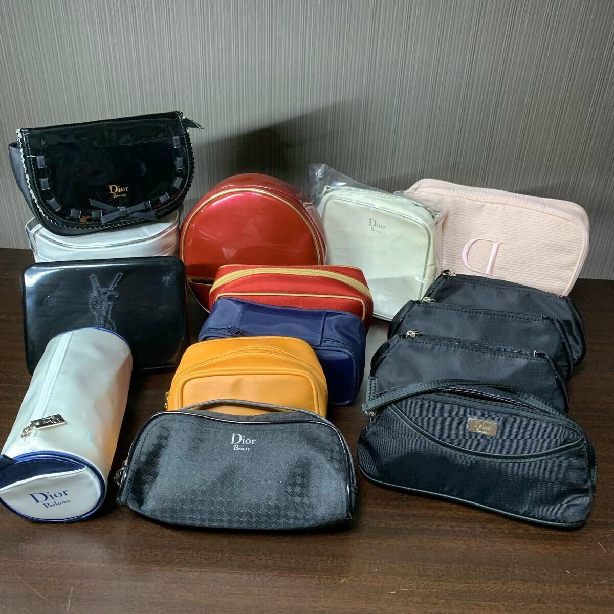 Assorted Dior and YSL novelty cosmetic pouches and mini bags arranged on a table showing multiple colors and shapes.