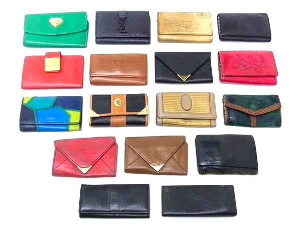 Seventeen assorted Yves Saint Laurent leather key cases and small wallets arranged on a white background.