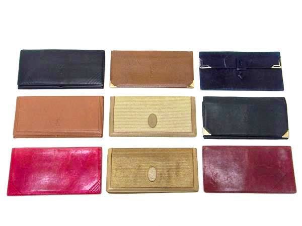 Nine Yves Saint Laurent wallets in various colors arranged in three rows on a white background.