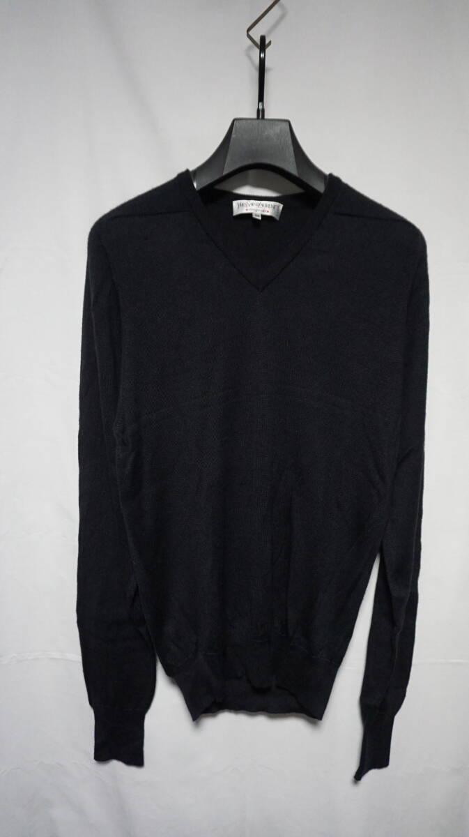 Front view of a dark V-neck sweater hanging on a hanger.