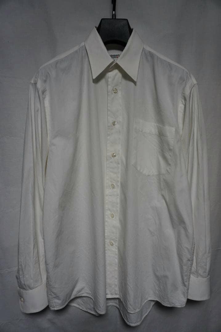 Front view of a white Yves Saint Laurent men's cotton shirt on a hanger showing the collar, button placket, and chest pocket.
