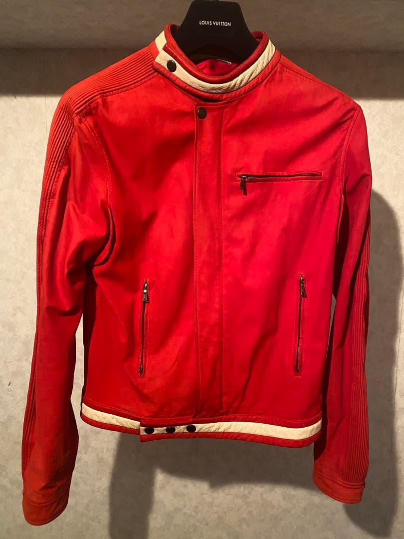 Front view of a red men's silk YVES SAINT LAURENT RIVE GAUCHE rider jacket on a hanger, showing zip pockets and contrasting cream trim.