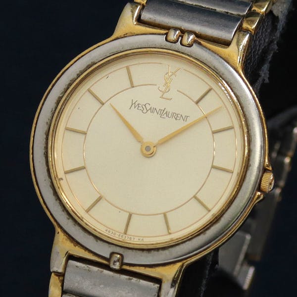 Front view of an Yves Saint Laurent men's wristwatch with an ivory dial and two-tone metal case and bracelet.