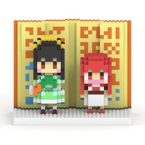 Front view of two block-style plastic figures of ティオ and 大海恵 standing on a white base with a yellow patterned backdrop.