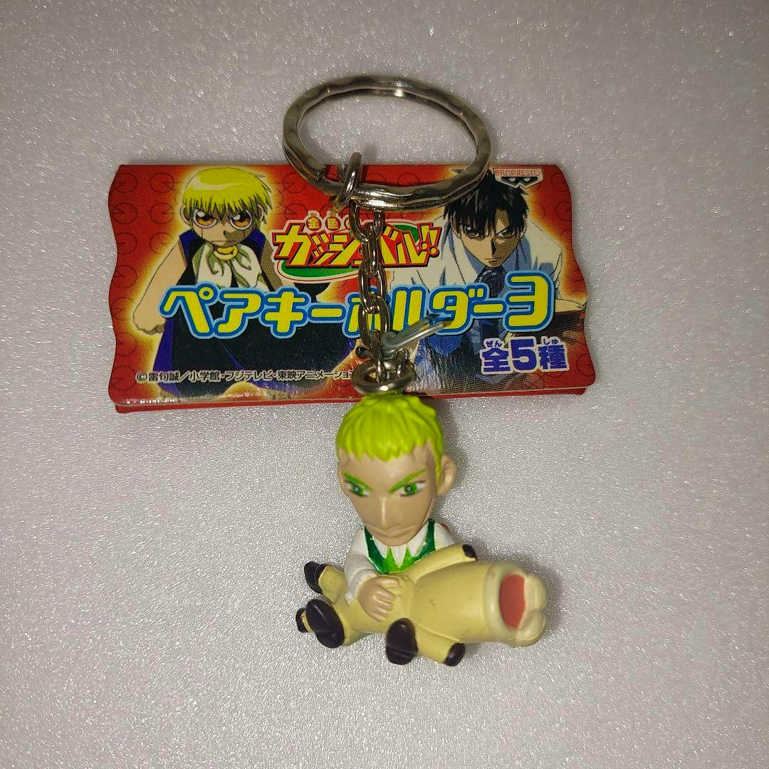 Plastic Gash Bell character keychain on a metal keyring with an attached cardboard tag showing Japanese text.