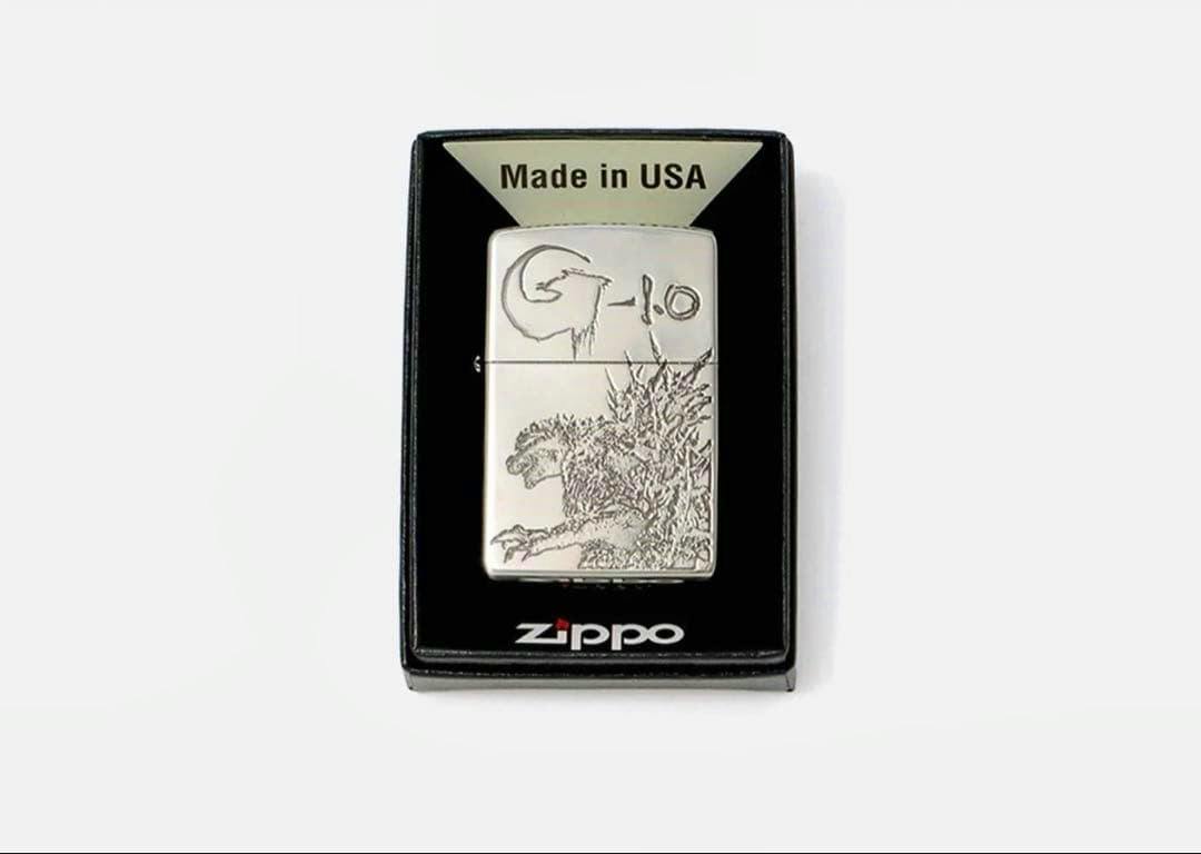 Metal Zippo lighter case with Godzilla engraving displayed in a black Zippo box.