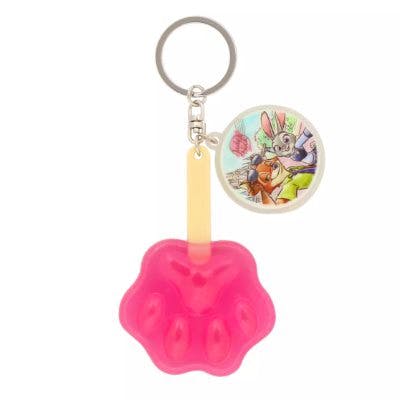 Plastic Zootopia keychain showing a pink paw-shaped charm and a round printed character charm on a metal key ring.