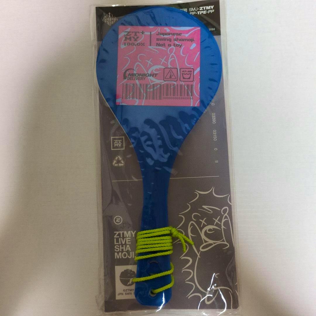 Front view of the blue cleaning wiper (shamoji) in its clear plastic packaging with a green cord wrapped around the handle.